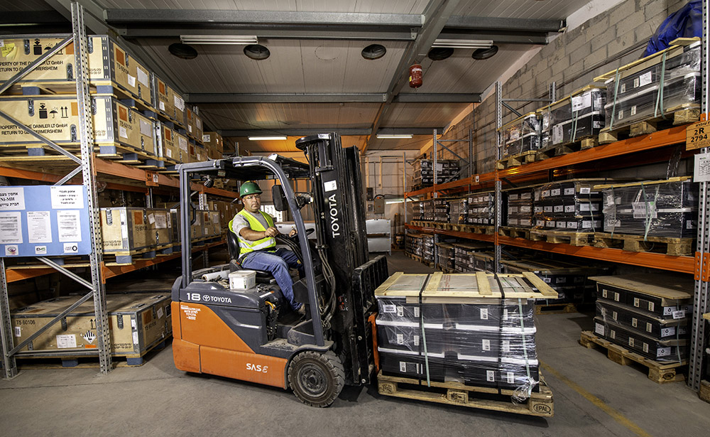 Working on a forklift in a warehouse